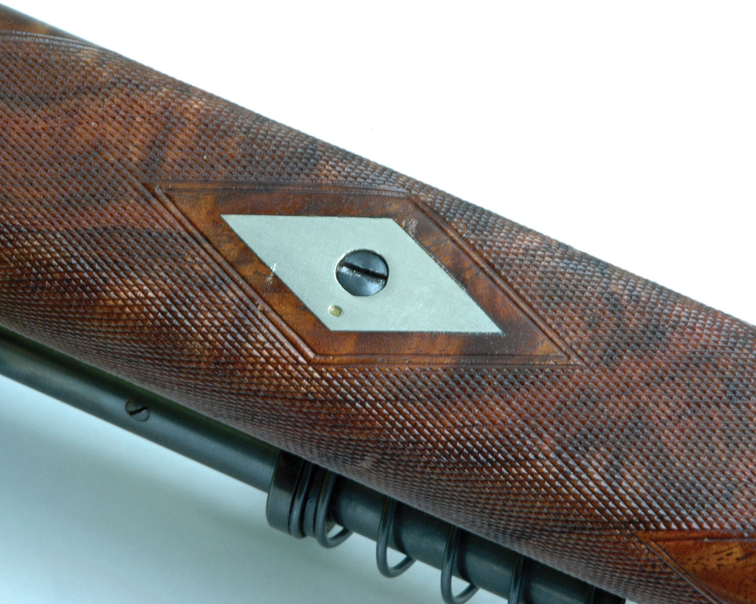 The forearm is attached directly to the barrel with the head of the screw enclosed in a silver escutcheon. Layne accidentally added the small dent during his first varmint shoot with the rifle.