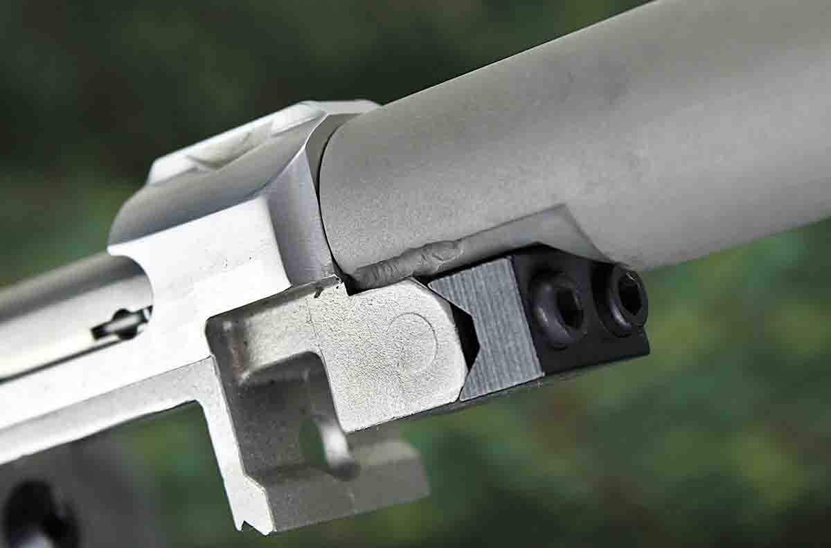 One of two welds affixing the suppressor shroud to the rifle barrel is visible above the V-block.